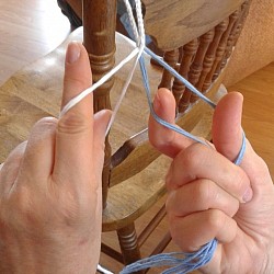 Twist both wrists in the same direction, to the right. The top string goes to the bottom while the bottom one goes to the top.  Now arrange your fingers back to their original position while leaving the strings in their new position